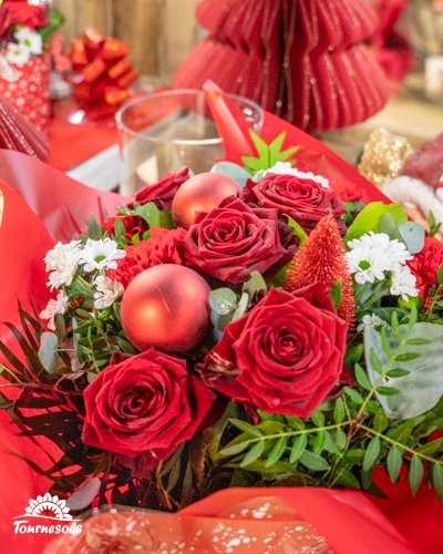 Bouquet de roses rouges et décoration de Noël avec feuillage vert.